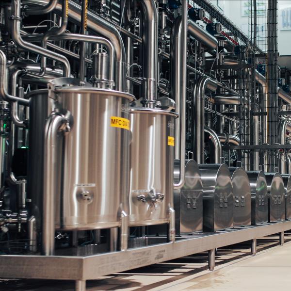 Static image of a factory floor, with silver machinery in view. 