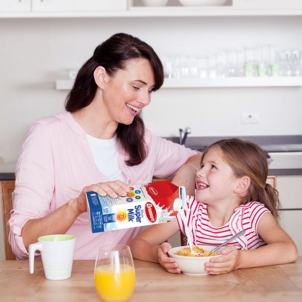Mother pouring Avonmore Supermilk into her daughter's bowl of cereal