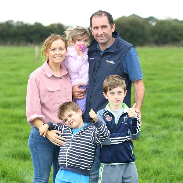 Glanbia Ireland farmer standing in a field with his young family