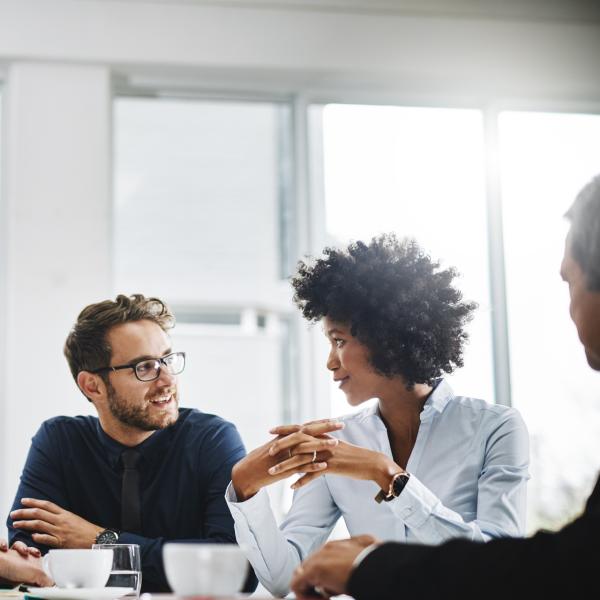 group of coworkers sitting at a table discussing work