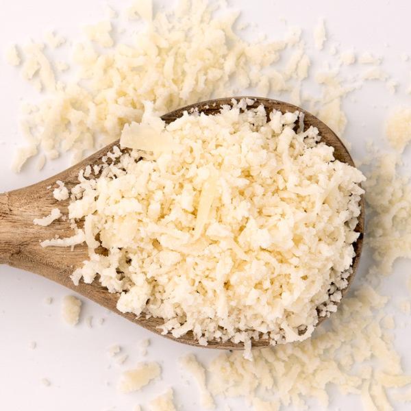 wooden spoon full of grated cheese