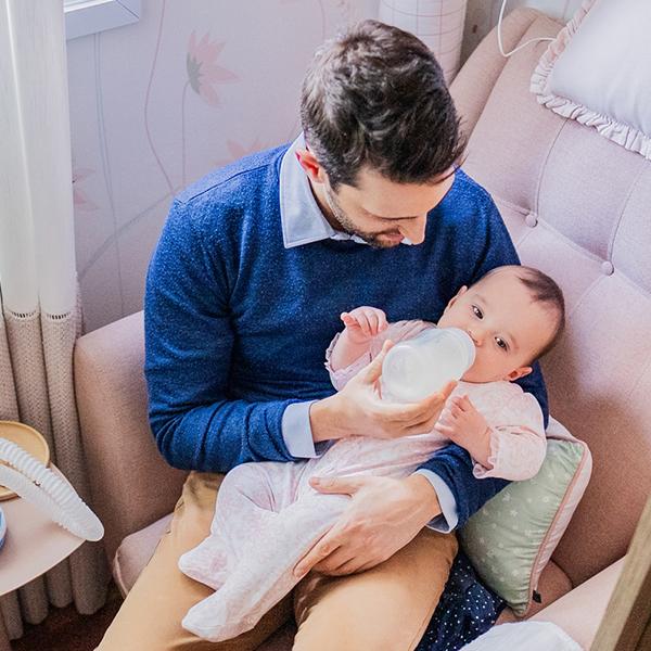 man feeding baby with bottle