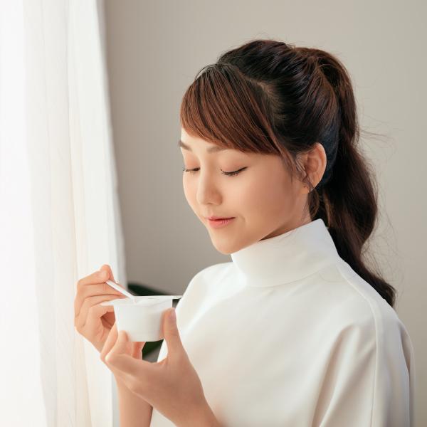 image of a woman eating a yoghurt