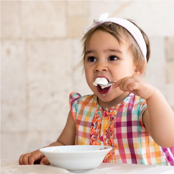 image of a young girl eating yoghurt