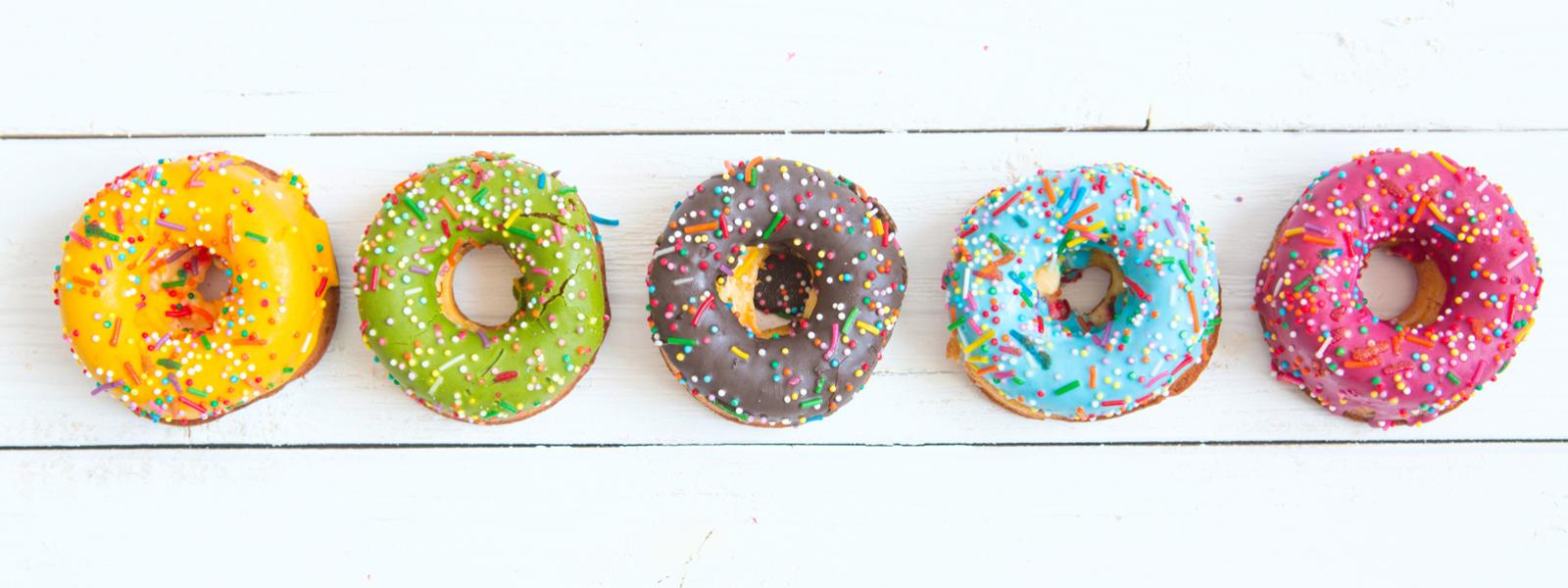 Five Dooughnuts of different colours placed in a line