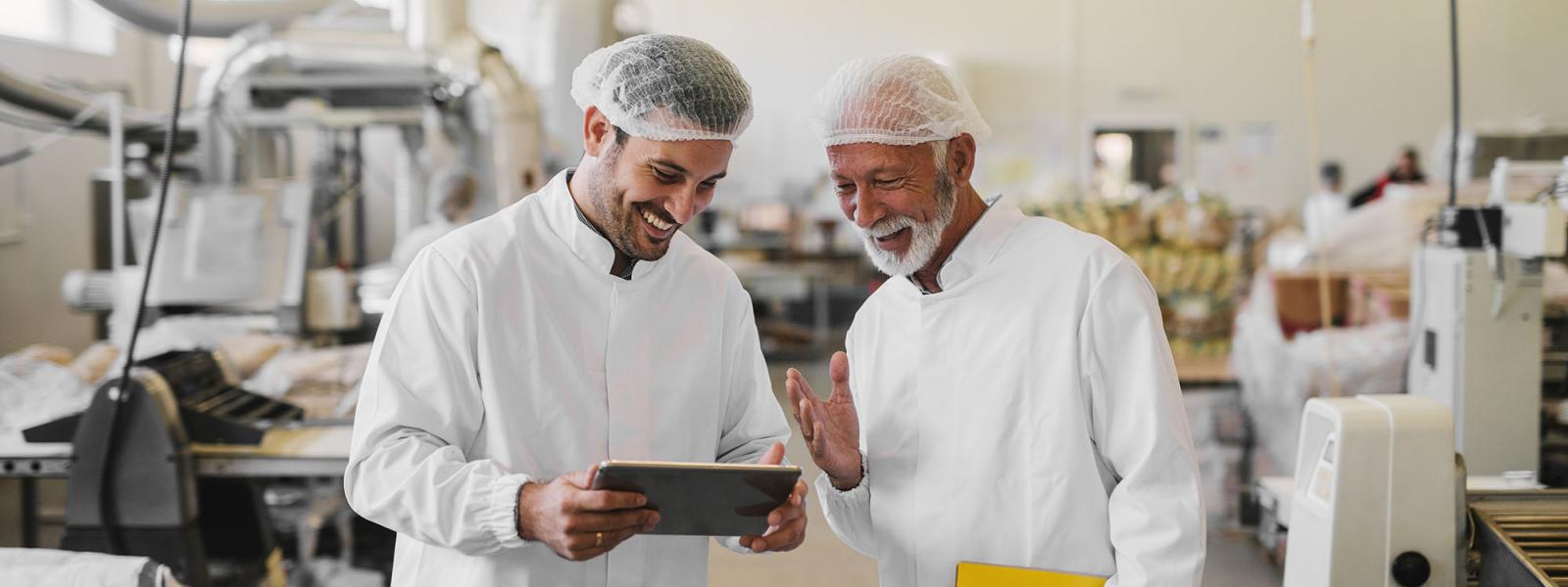 Two men talking in a factory setting