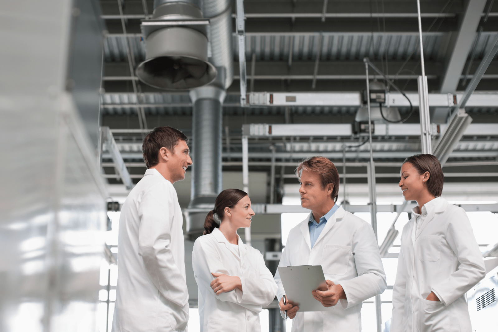 image of four workers in lab coats in conversation